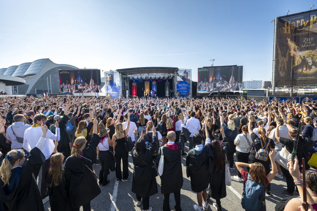 Ein magischer Moment: Die Besucher:innen halten die Zauberstäbe in die Luft